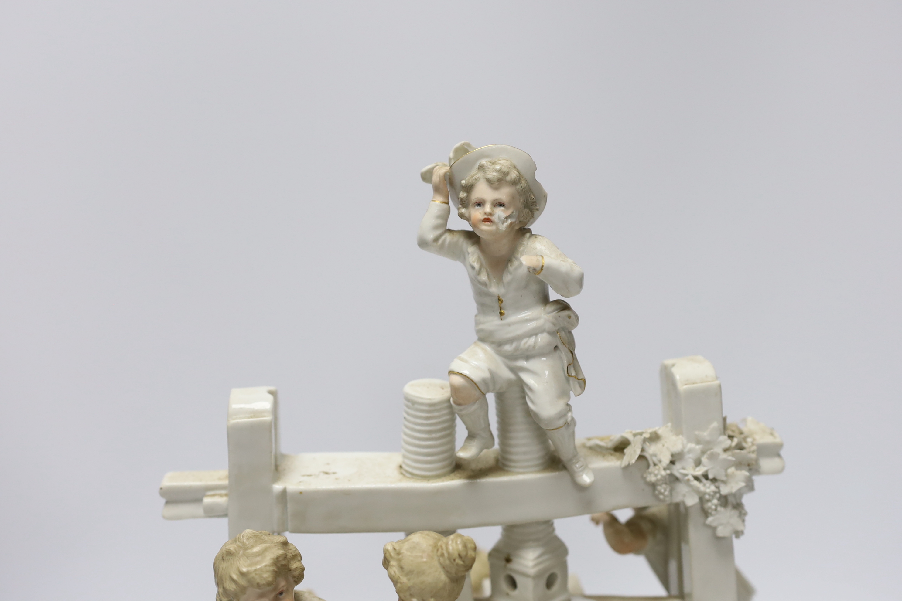 A late 19th century German white glazed porcelain group, ‘’The Wine Press’’, after a Meissen original by Johann Carl Schonheit, 33cm